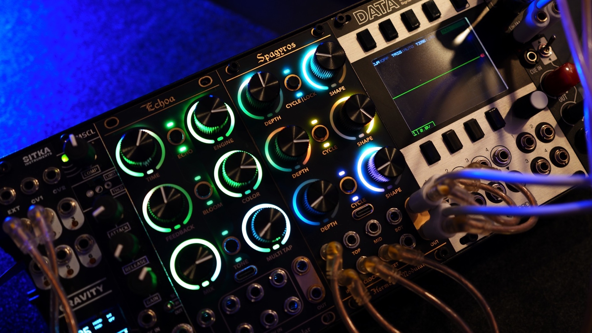 Echoa and Spagyros racked side by side in a patched Eurorack system with illuminated RGB LED rings around every knob