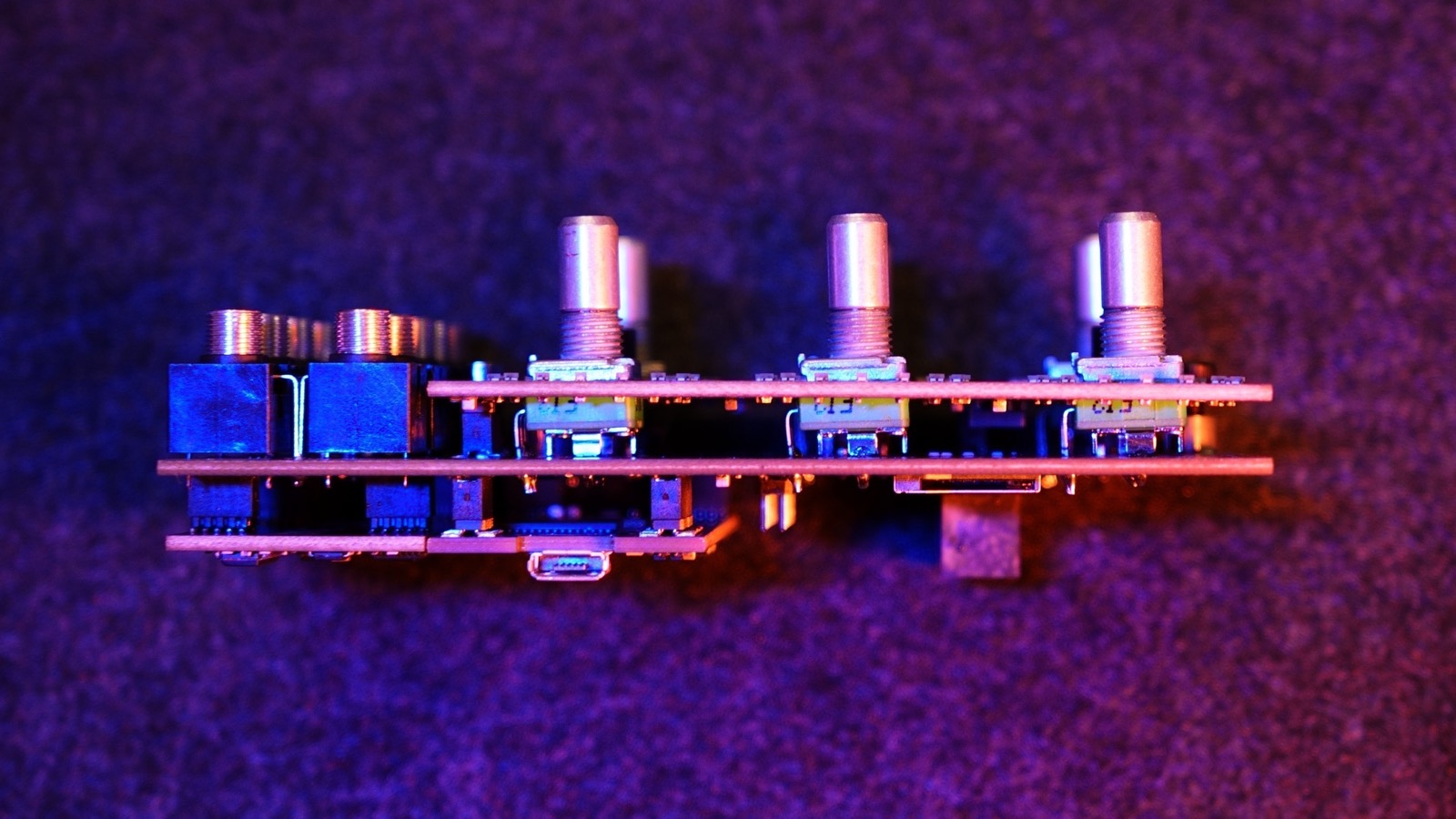 Side profile of the Alchemy Lab board stack showing jacks, pots, and the front USB-C port between two circuit boards